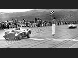 Al Torres waves the checkered flag as Carroll Shelby in the Edgar Ferrari 410 Sport bests Phil Hill in the Ferrari Monza at Palm Springs, November 1956.