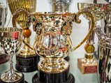 Collection of Ornate Racing Trophies, Awards, and Acknowledgements with Glass Display Table
