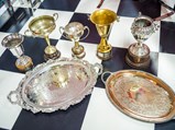 Collection of Ornate Racing Trophies, Awards, and Acknowledgements with Glass Display Table